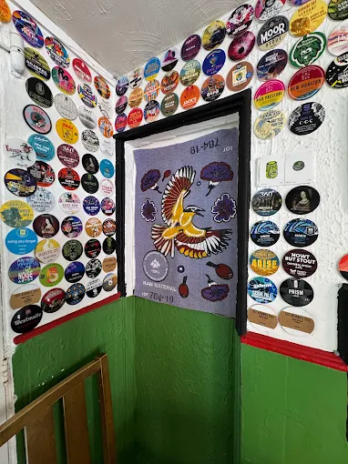 The Patch — coaster-covered walls around a painted doorway